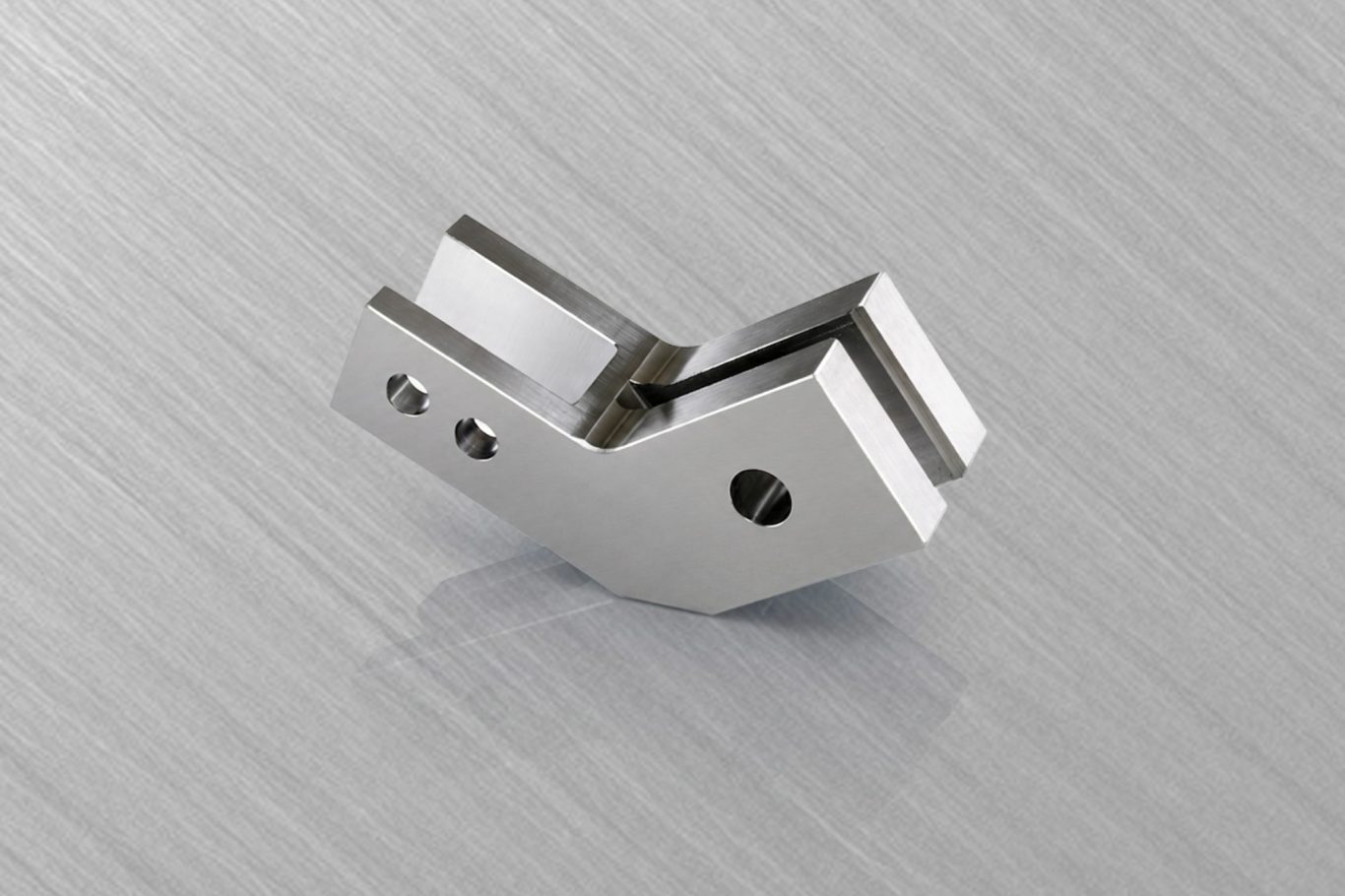 Metallverbindungselement mit zwei vertikalen Bohrungen auf einer glatten Oberfläche.